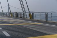 the side of a bridge crossing over the ocean, with a bike and pedestrians in traffic