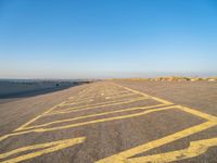 a road with yellow painted arrows on it at the beach in summertime or fall