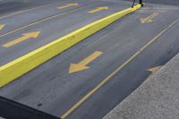 a yellow painted handrail is at the side of a street, with parking spaces on each side