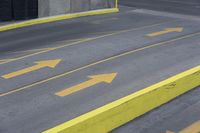 a yellow painted handrail is at the side of a street, with parking spaces on each side