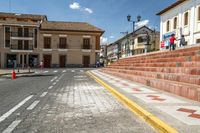 a red and white checkered stone and concrete staircases leading down a street lined with townhouses