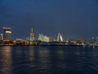 a city skyline at night lit up with bright lights reflecting in the water and a boat coming toward it