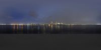 night time photograph of city lights and a body of water at night time with an orange dot in the middle of the frame