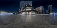 the night view of a modern city plaza with skyscrapers in the background and a full moon is seen