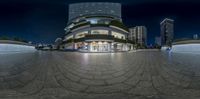 a very nice looking looking circular building with nice lighting on the windows in it at night