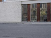 a young boy on a skateboard in front of a store window next to a street