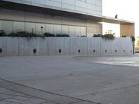 a young boy doing tricks on a skateboard at the park and the building with the reflection