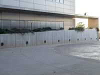 a young boy doing tricks on a skateboard at the park and the building with the reflection