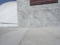 a young man skateboards past a giant screen with a photo of a shark on it