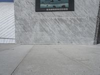 a young man skateboards past a giant screen with a photo of a shark on it