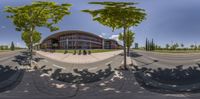 a circular image of the outside of a building with motorcycles on the street and some trees