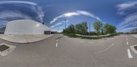 a fish eye lens is seen on a paved road as the photographer takes pictures in the back ground