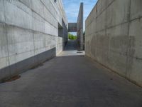 the empty parking lot in front of a wall with apartment buildings on it and a skateboarder on a ramp