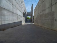 the empty parking lot in front of a wall with apartment buildings on it and a skateboarder on a ramp