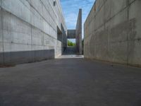 the empty parking lot in front of a wall with apartment buildings on it and a skateboarder on a ramp