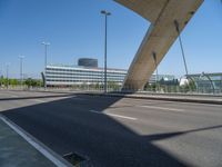 a truck driving across a bridge near a street corner near buildings and a bridge with many cables