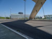 a truck driving across a bridge near a street corner near buildings and a bridge with many cables