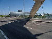 a truck driving across a bridge near a street corner near buildings and a bridge with many cables