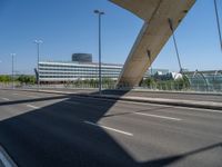 a truck driving across a bridge near a street corner near buildings and a bridge with many cables