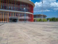 a concrete structure made into rows of orange and yellow poles are on a cement sidewalk