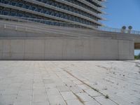 a black fire hydrant is sitting in the concrete area in front of a large building