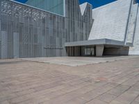 a white building with several steps and large glass panels in the facade is a mosaic that depicts a man