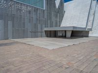 a white building with several steps and large glass panels in the facade is a mosaic that depicts a man