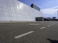 the large building has white brick on it's sides and has graffiti on the pavement