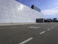 the large building has white brick on it's sides and has graffiti on the pavement