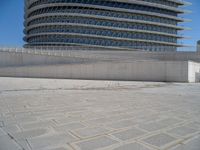 a black fire hydrant is sitting in the concrete area in front of a large building