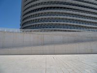 a black fire hydrant is sitting in the concrete area in front of a large building