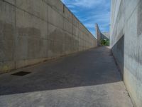 the empty parking lot in front of a wall with apartment buildings on it and a skateboarder on a ramp