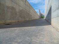 the empty parking lot in front of a wall with apartment buildings on it and a skateboarder on a ramp