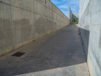 the empty parking lot in front of a wall with apartment buildings on it and a skateboarder on a ramp