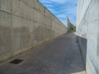 the empty parking lot in front of a wall with apartment buildings on it and a skateboarder on a ramp