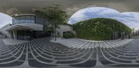 a 360 - view of a circular building outside of it's entranceway with hedges and stairs