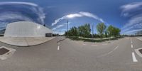 a fish eye lens is seen on a paved road as the photographer takes pictures in the back ground