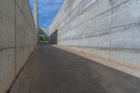 the empty parking lot in front of a wall with apartment buildings on it and a skateboarder on a ramp