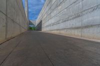 the empty parking lot in front of a wall with apartment buildings on it and a skateboarder on a ramp