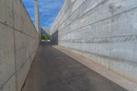 the empty parking lot in front of a wall with apartment buildings on it and a skateboarder on a ramp