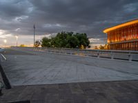 there is a large cement bridge over the road on a cloudy day with tall buildings in the background