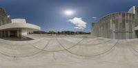 the skateboarder is in front of an artistic building while the sun shines