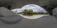 a picture of a very curved area in a park filled with people skateboarding and riding on it