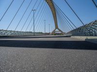 a truck driving across a bridge near a street corner near buildings and a bridge with many cables