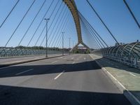 a truck driving across a bridge near a street corner near buildings and a bridge with many cables