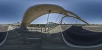 a fish eye view of a bridge and road from the sidewalk, taken by a fisheye lens