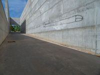 the empty parking lot in front of a wall with apartment buildings on it and a skateboarder on a ramp