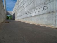 the empty parking lot in front of a wall with apartment buildings on it and a skateboarder on a ramp