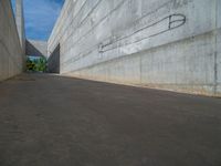 the empty parking lot in front of a wall with apartment buildings on it and a skateboarder on a ramp