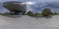 the skate park is empty and the man is riding his skateboard in the middle